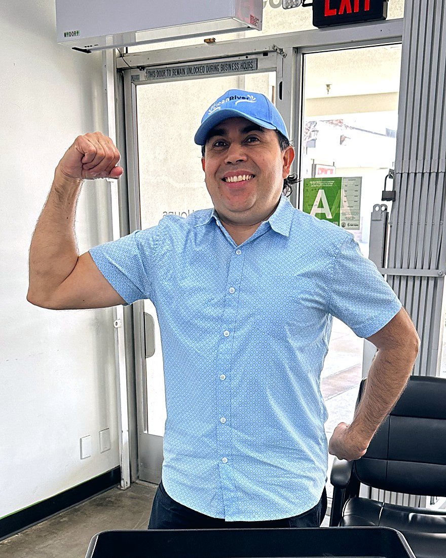 Our team member in a Clean River cap, smiling and flexing in the Santa Clarita store