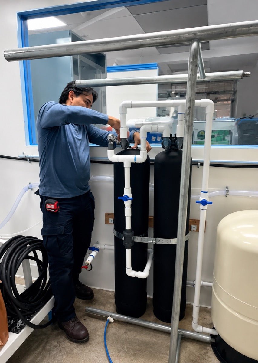Technician servicing water filtration tanks at Clean River Water Store in Santa Clarita